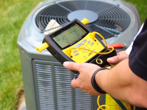 An AC tech checking the AC during regular maintenance