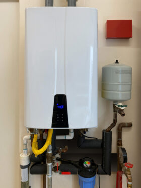 Tankless hot water heater mounted on wall of Dallas home